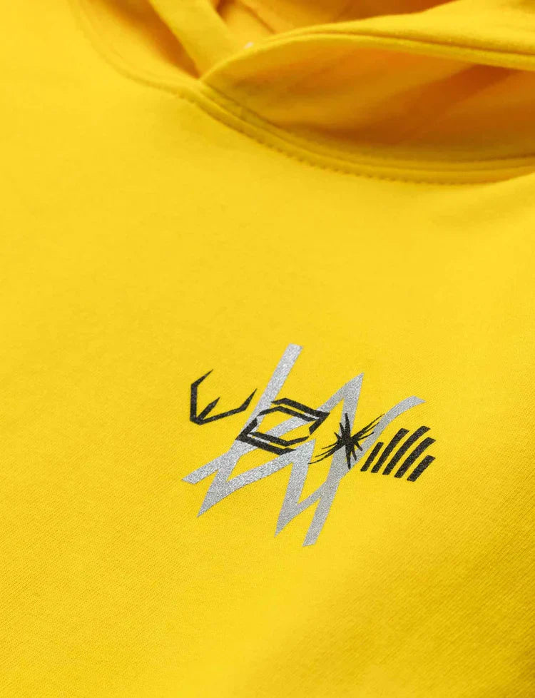 Zoomed-in view of the intricate Alan Walker logo embroidery on yellow kids' hoodie.