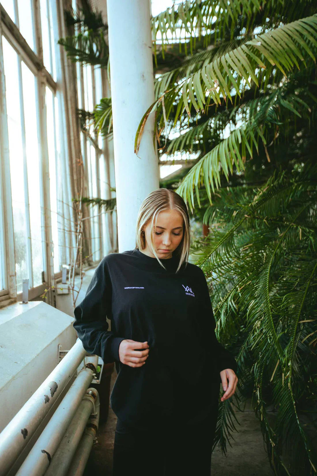 model in Melting Rose Longsleeves bringing a touch of urban style to the lush greenery of a botanical setting.
