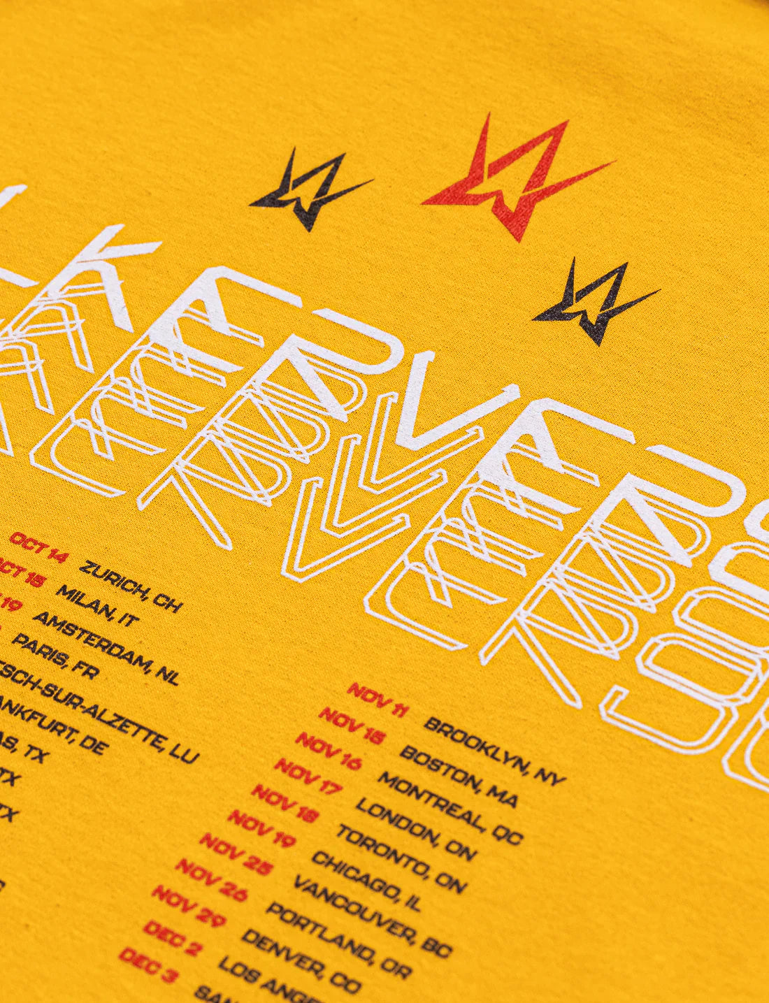 Detailed view of the back of a yellow t-shirt featuring the 'Walkerverse' text in white, tour dates in orange, and red Alan Walker logos, emphasizing the vibrant color contrast.