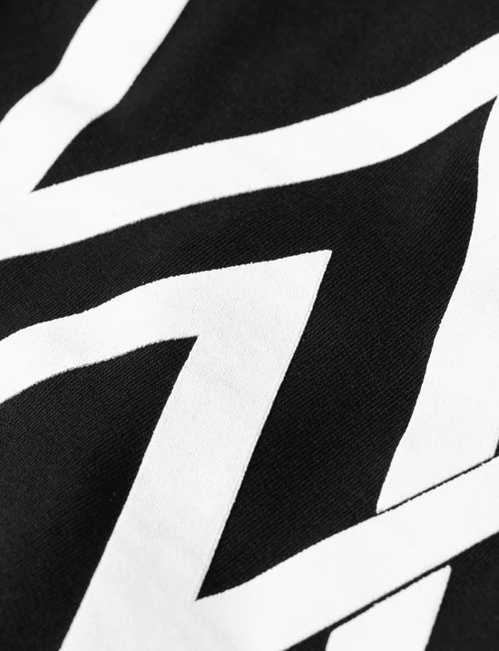Detail on the sleeve of the kids black hoodie showing the unique Alan Walker patch, a subtle branding touch.