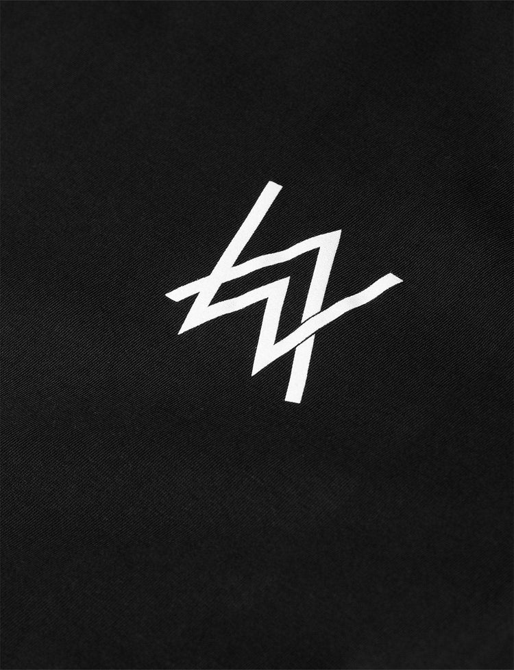 Close-up of a white Alan Walker logo on black fabric, highlighting the sharp contrast and clean lines of the design.