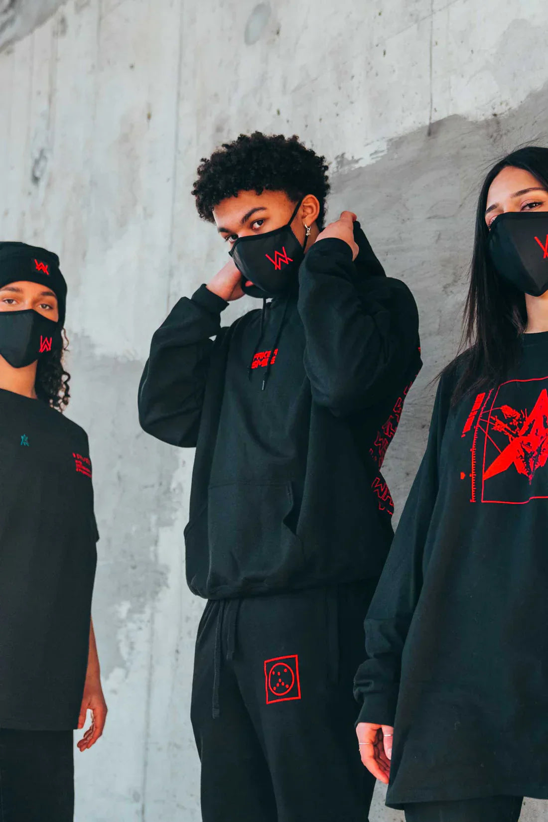 Lifestyle shot of diverse individuals wearing Alan Walker merchandise including the Fake a Smile Hoodie, showcasing the unified style of the World of Walker collection.