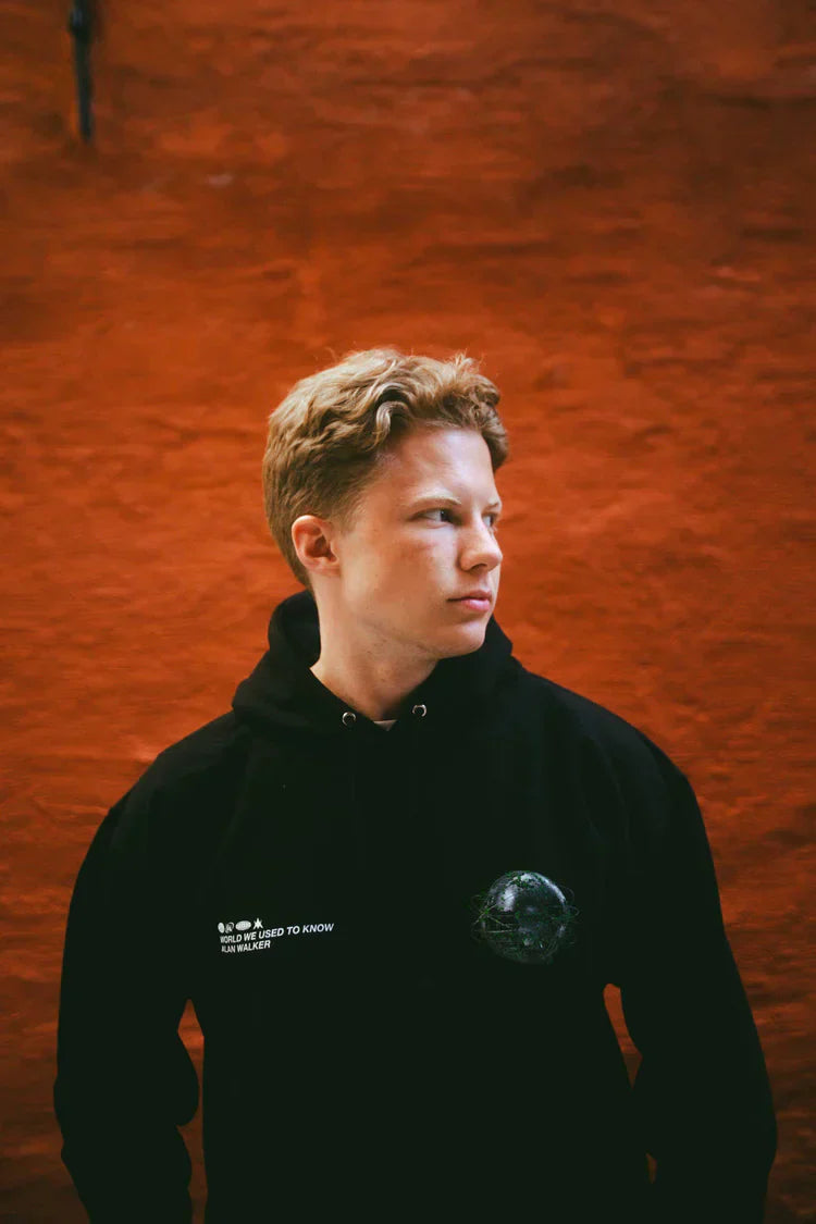 Person wearing a black 'World We Used To Know' hoodie with a contemplative expression.